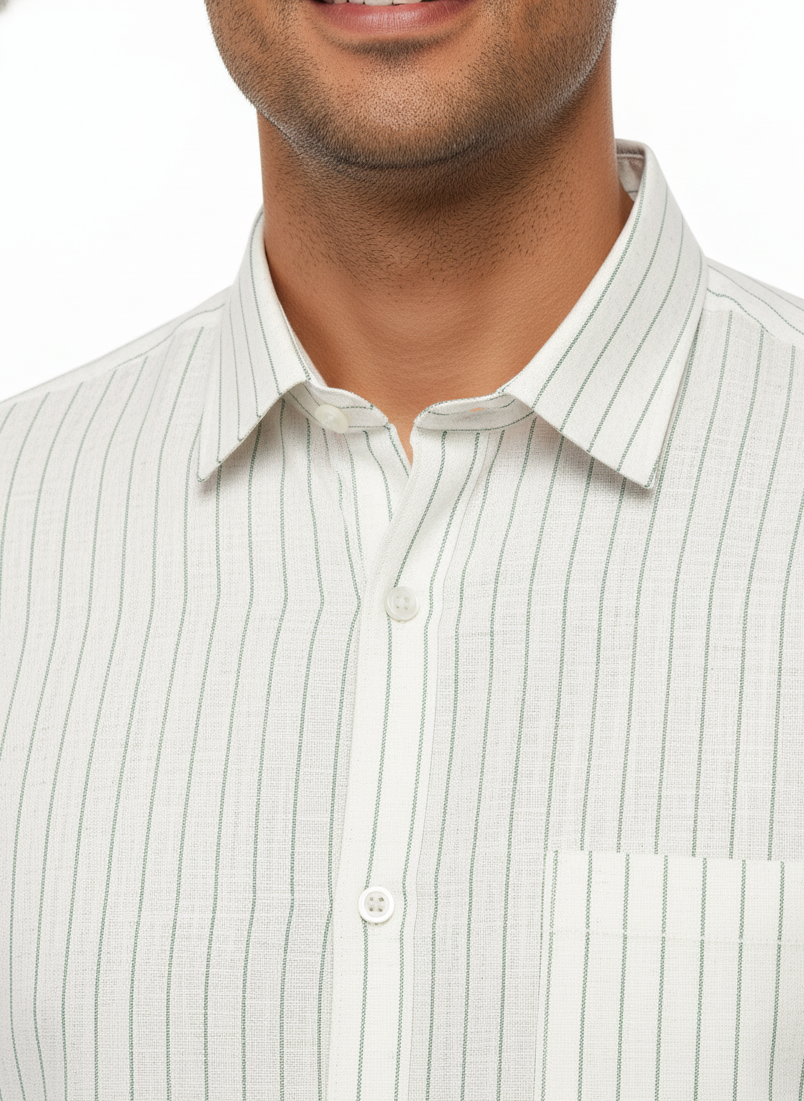 Close-up of a man wearing a light-colored striped shirt with a white background