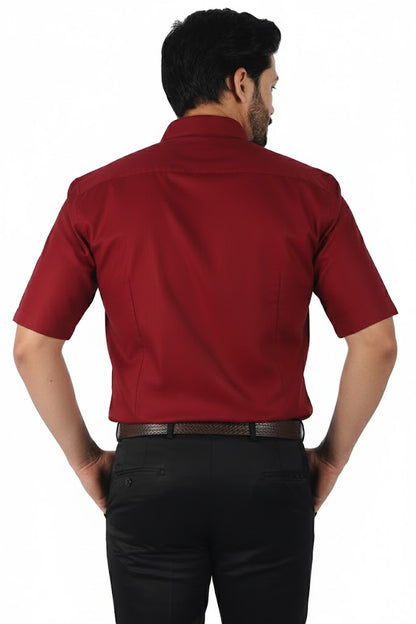 Man wearing a red shirt and black pants on a white background